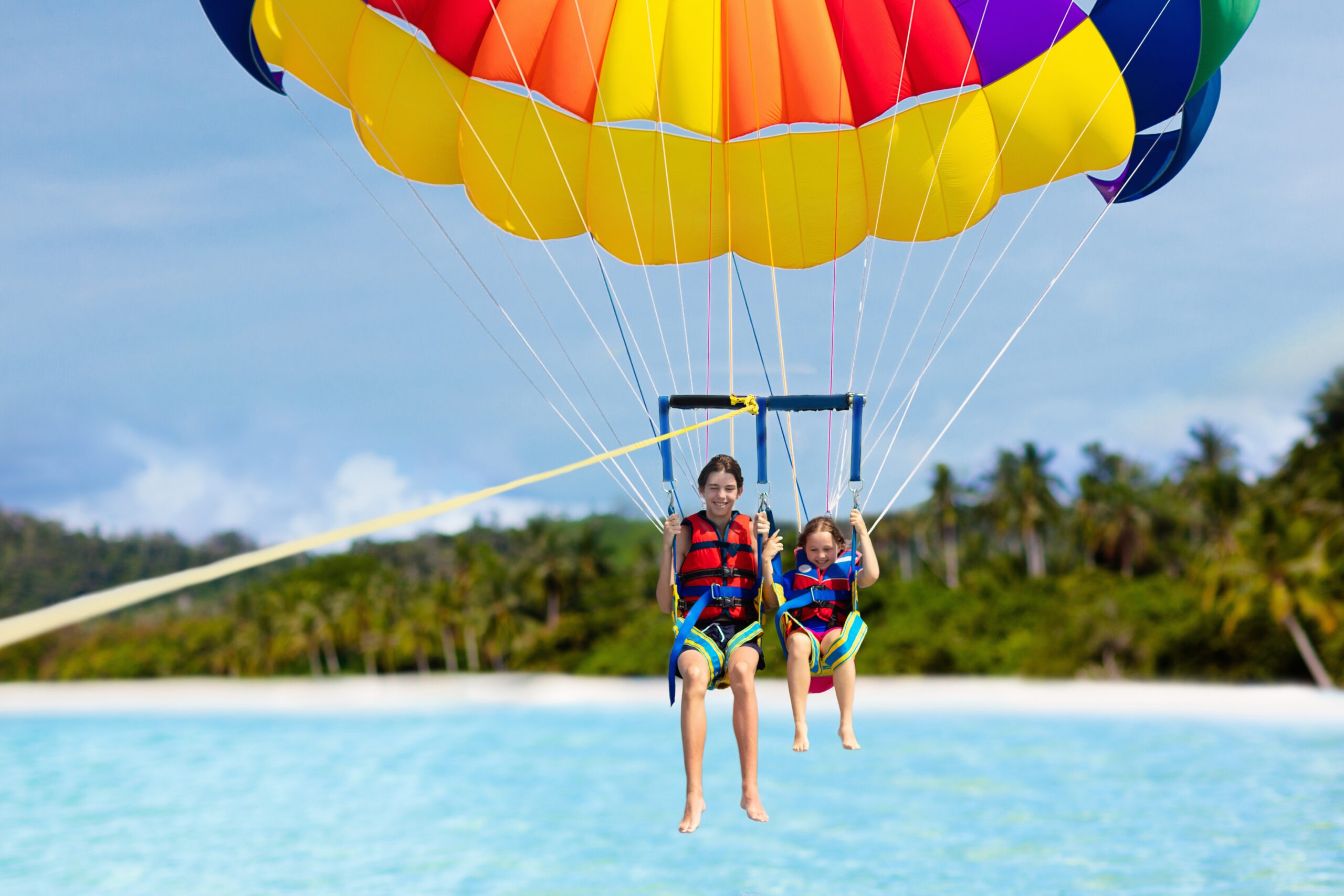 Kids parasailing. Water sport on summer vacation.