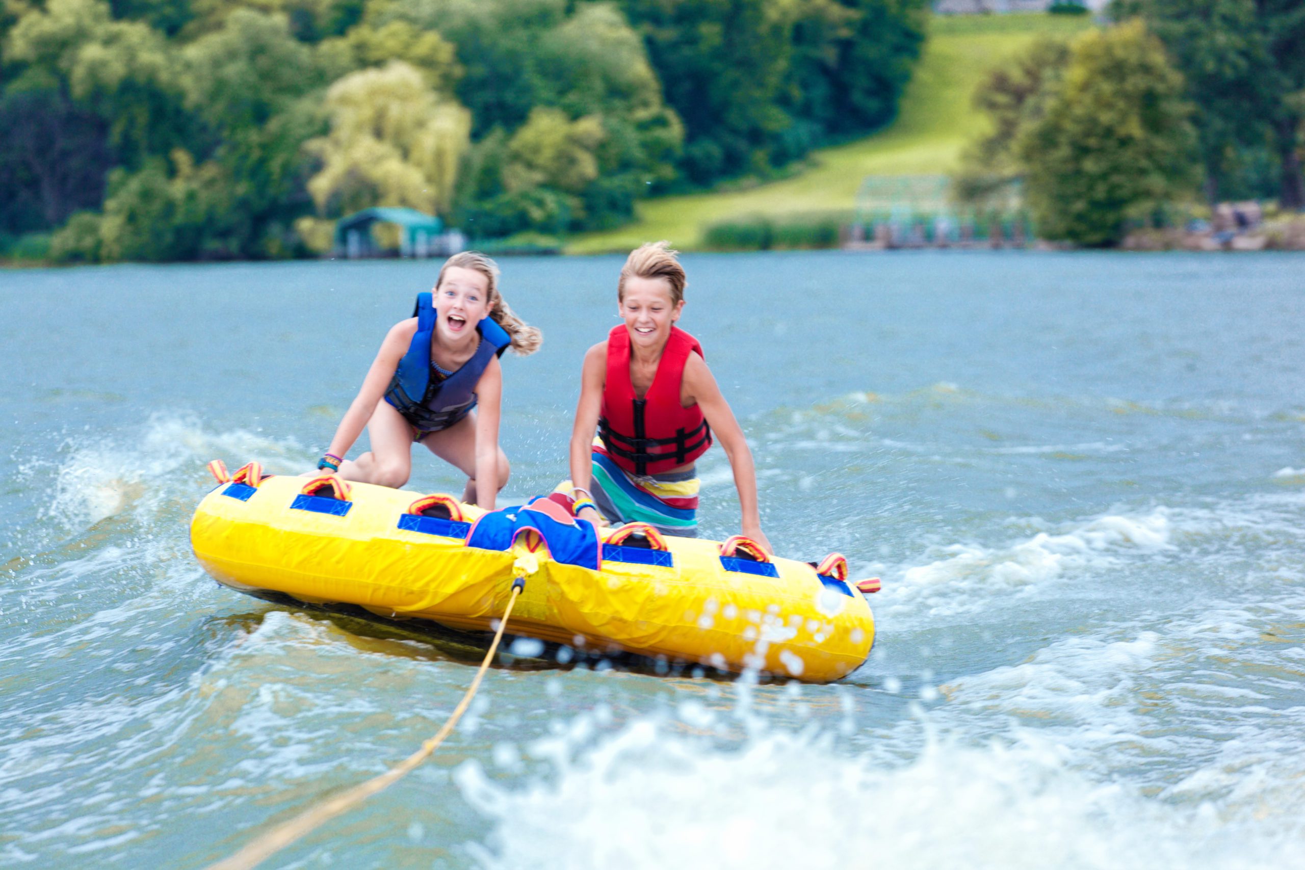 Boy and Girl Children Tubing on Minnesota Lake in Summer